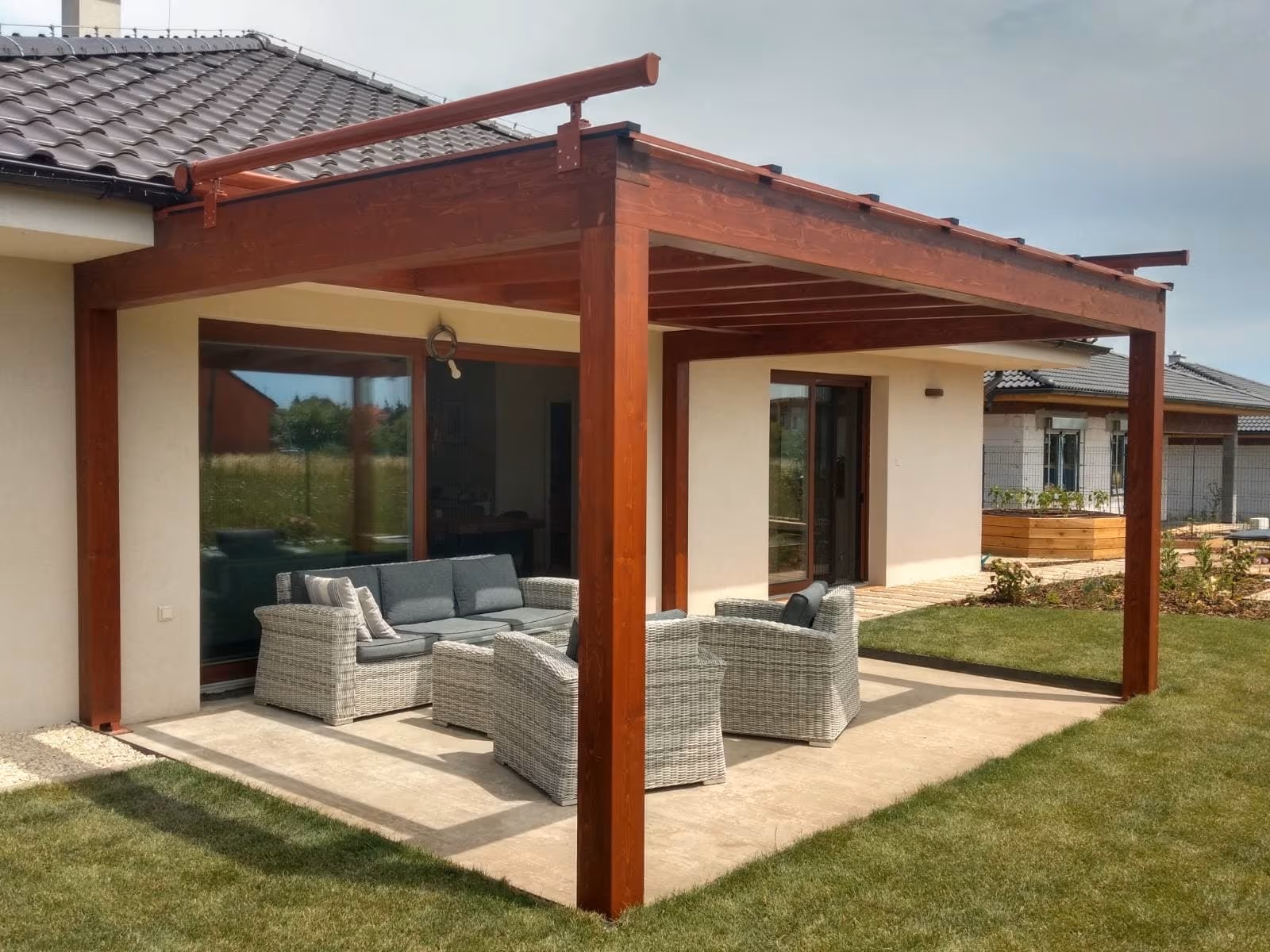 Milano fa pergola ratanbútorral egy kertben