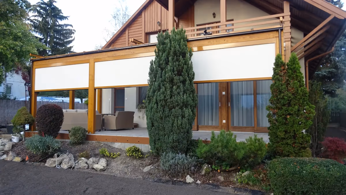 Milano fa pergola örökzöld fák között egy teraszon