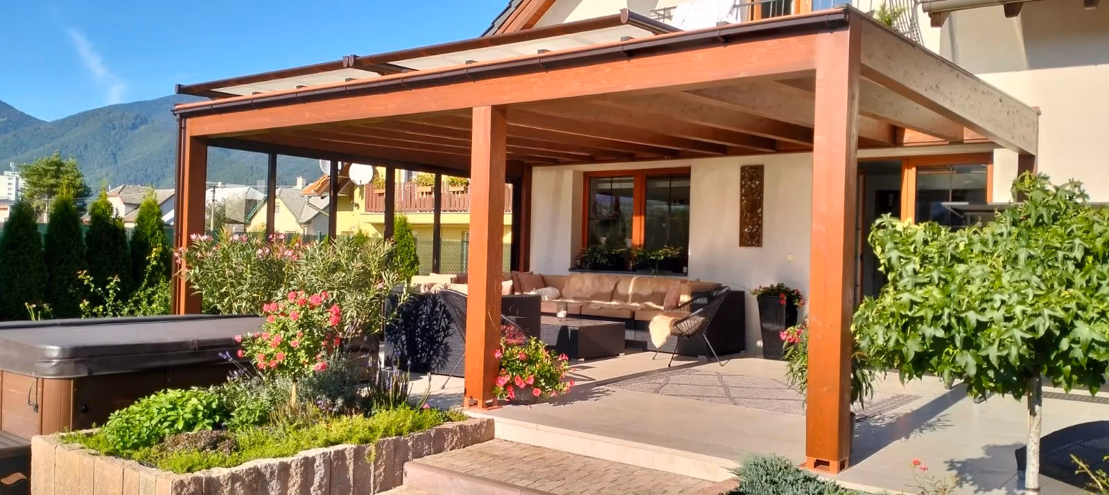 Milano fa pergola ülőgarnitúrával egy sötét színű családi ház mellett