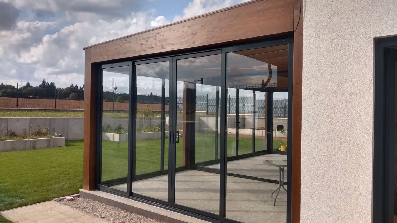 Milano fa pergola üvegezett oldalfallal és tolóajtókkal