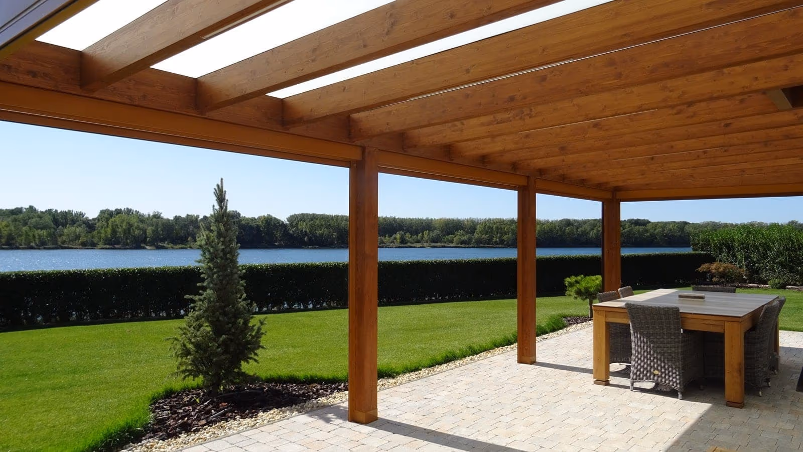 Méretre készített fa pergola egy rendezett kerti terasz fölött